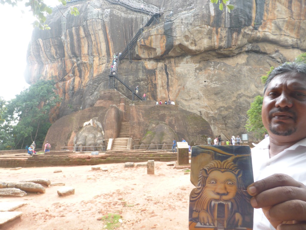 Our guide holding the photo showing what Lion rock used to look like.  Now only the paws are there. 